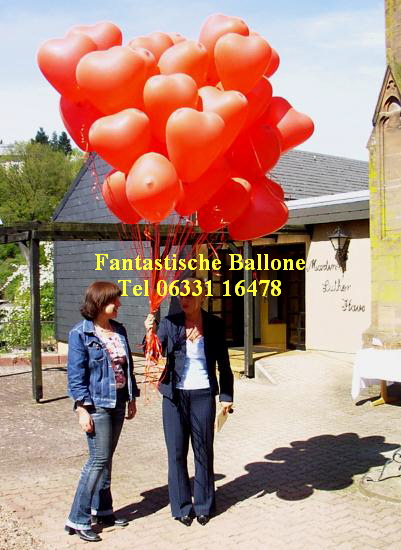 Brautmama mit Herzballons vor der Kirche